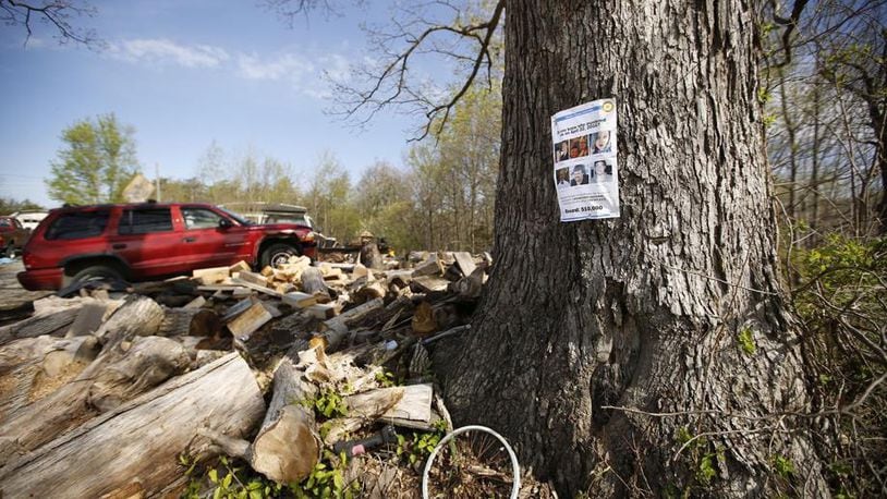 A reward poster for information about the Rhoden murders hangs in a tree outside the home of Leonard Manley, whose daughter Dana Rhoden, 37, was one of the eight victims in Pike County on April 22, 2016. The case remains unsolved. TY GREENLEES / STAFF