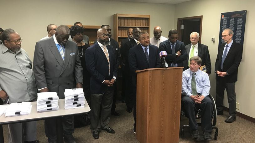 Attorney Michael Wright speaks about the civil rights complaint filed against Premier Health, surrounded by west side clergy who brought the complaint over the planned closure of Good Samaritan Hospital. KAITLIN SCHROEDER/STAFF