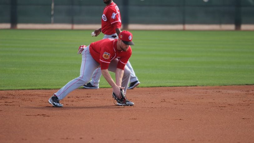 Zack Cozart fields a ground ball Friday during the Reds first full-squad workout of spring training in Goodyear, Ariz. STAFF PHOTO/MIKE HARTSOCK