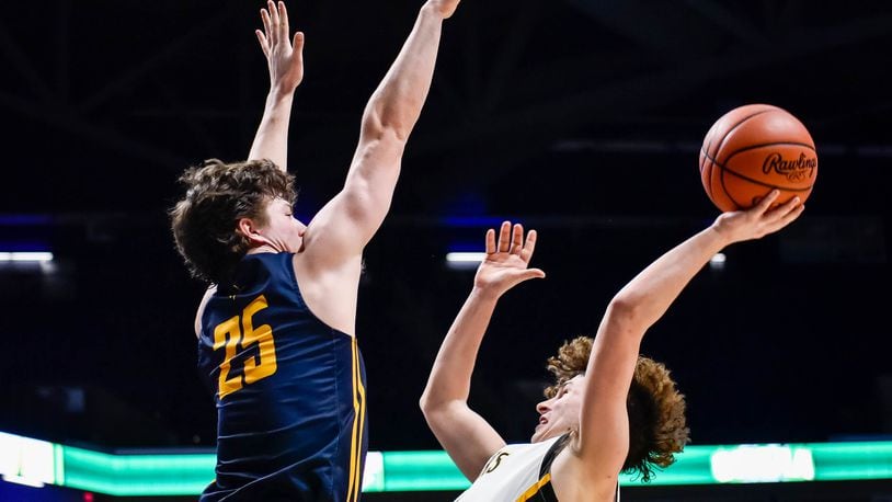Centerville's Drew Thompson puts up a shot defended by Archbishop Moeller's Michael Currin March 11, 2020 in their Division I Regional boys basketball semifinal at Xavier University's Cintas Center. NICK GRAHAM / STAFF