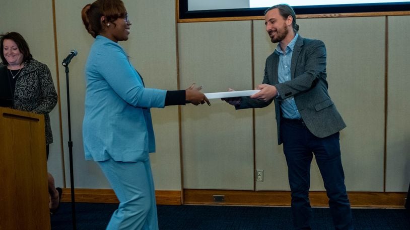 Sinclair Community College's College Credit Plus coordinator, Cyrus Stork, presents Kaeli Wesley her associate degree. Photo courtesy of Sinclair Community College.