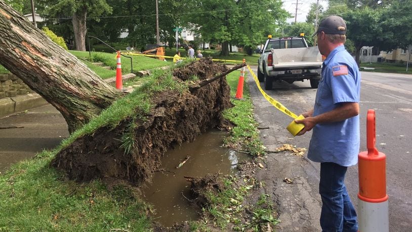 Utility crews used caution tape to rope off a section of sidewalk on S. Maple in Eaton were a tree was uprooted during a storm Tuesday afternoon that brought rough winds and heavy rain through the region. KATE BARTLEY/STAFF