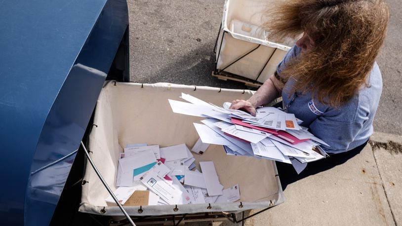 A postal worker removes mail from an outdoor Kettering post office. Police this past weekend in Kettering arrested three people in connection with a suspected theft of mail at the United States Post Office at 1490 Forrer Boulevard. JIM NOELKER/STAFF