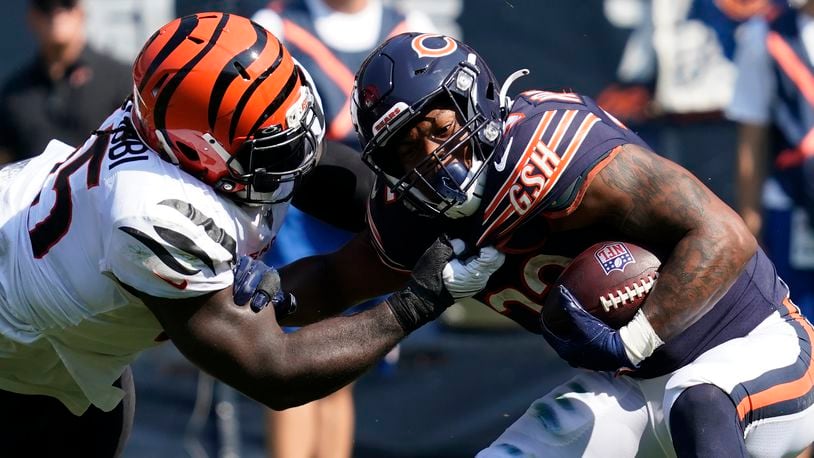 Cincinnati Bengals defensive tackle Larry Ogunjobi (65) pulls Chicago Bears running back David Montgomery down by the jersey during the second half of an NFL football game Sunday, Sept. 19, 2021, in Chicago. (AP Photo/Nam Y. Huh)