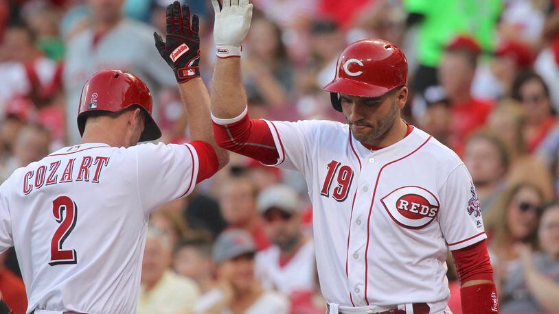 The Reds’ Zack Cozart, left, slaps hands with Joey Votto after hitting a home run against the Diamondbacks on Wednesday, July 19, 2017, at Great American Ball Park in Cincinnati. David Jablonski/Staff