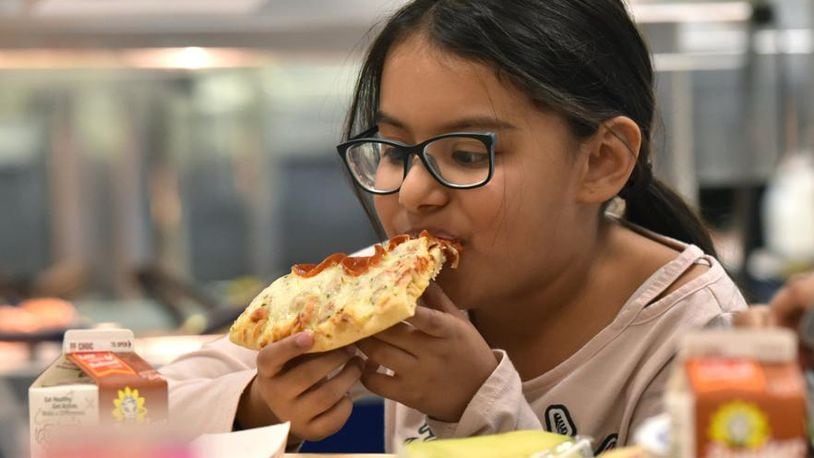 Student Angelic Ventura, 8, eats a slice of pizza with whole wheat crust for her lunch at Corley Elementary School on Wednesday, Dec. 12, 2018. Agriculture Secretary Sonny Perdue recently announced new school-meal guidelines designed to increase local flexibility in implementing nutrition standards for milk, whole grains and sodium.
