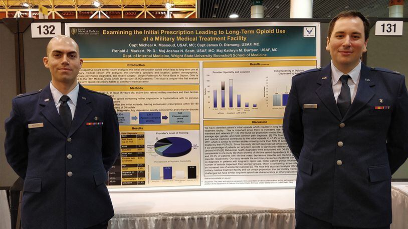 Capt. Micheal Massoud (left), stands with research associate Capt. James Dizmang in front of the poster highlighting patient-oriented research that earned Massoud an award in the annual American College of Physicians abstract and poster competition. (Courtesy photo)