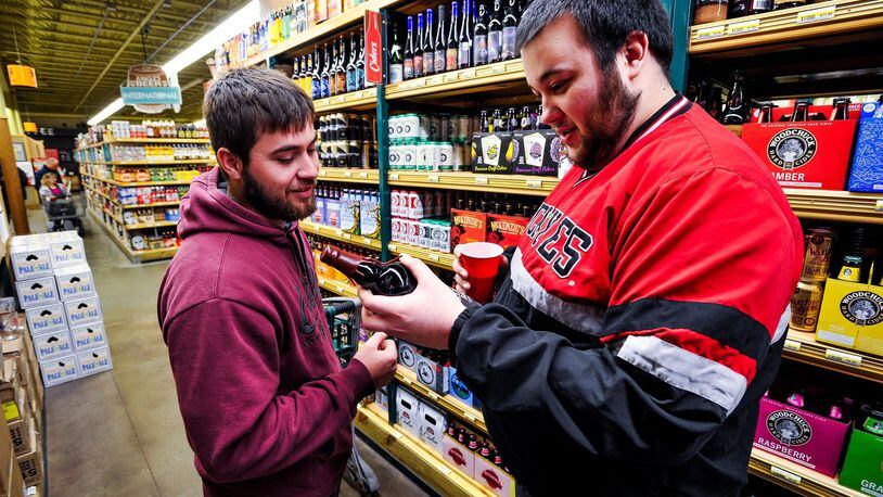 Brett Menser, left, and Alex Reindel drove from Tipp City to shop the large beer selection at Jungle Jim’s International Market in Fairfield for New Year’s Eve supplies. NICK GRAHAM/STAFF