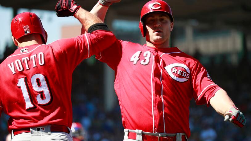 Cincinnati Reds first baseman Joey Votto (19), left, and Cincinnati Reds right fielder Scott Schebler (43) after Schebler's solo home run against the Chicago Cubs during the first inning on Sunday, Sept. 16, 2018 at Wrigley Field in Chicago, Ill. (Nuccio DiNuzzo/Chicago Tribune/TNS)