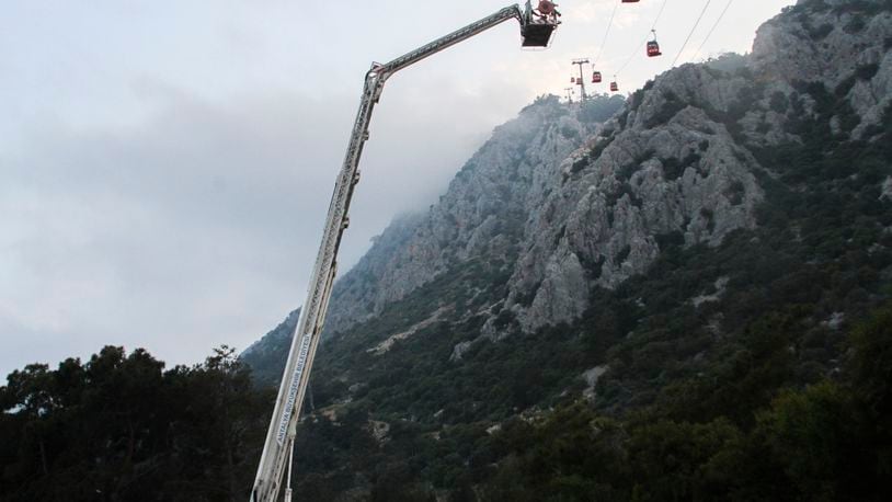 A rescue team work with passengers of a cable car transportation systems outside Antalya, southern Turkey, April, Friday 12, 2024. A cable car disaster in southern Turkey left one person dead and seven injured over the busy Eid al-Fitr public holiday on Friday, local media reported. (IHA via AP)