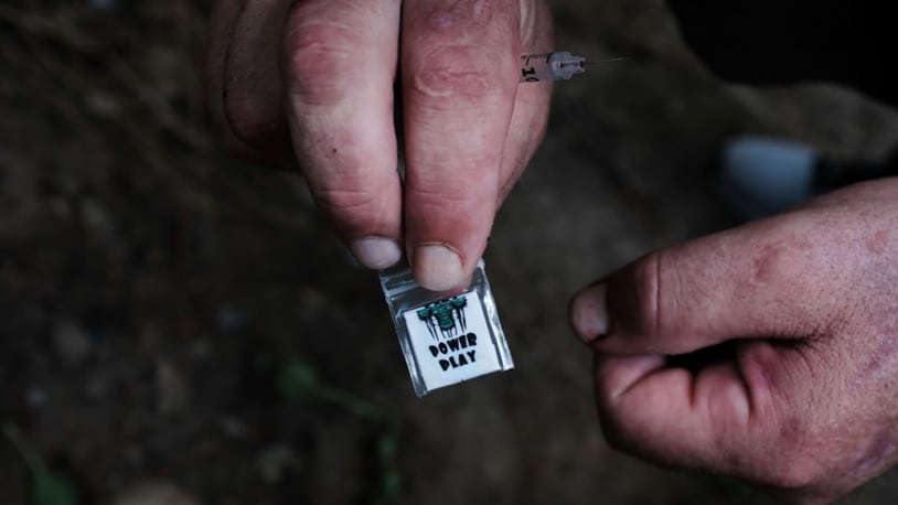 File photo: A homeless heroin addict displays a brand of heroin called "power play" which was purchased on the street for $5.(Photo by Spencer Platt/Getty Images)