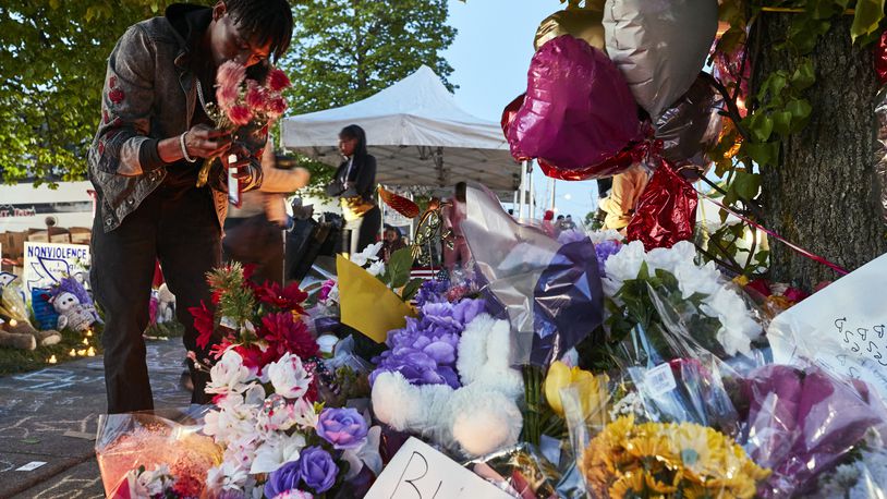 A man lays flowers on Tuesday, May 17, 2022, at a makeshift memorial to the victims of the racist mass shooting in Buffalo, N.Y. The accused gunman in Saturday’s massacre at a supermarket in Buffalo appeared in court on Thursday morning, May 19, 2022, facing a count of murder in the first degree, as some family members of the 10 people he is accused of killing looked on. (Mustafa Hussain/The New York Times)