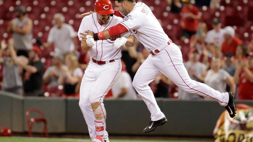 The Reds' Adam Duvall and Eugenio Suarez (No. 7) Reds celebrate after Duvall hit a run scoring single to beat the Diamondbacks 4-3 in the 11th inning at Great American Ball Park on Wednesday night.
