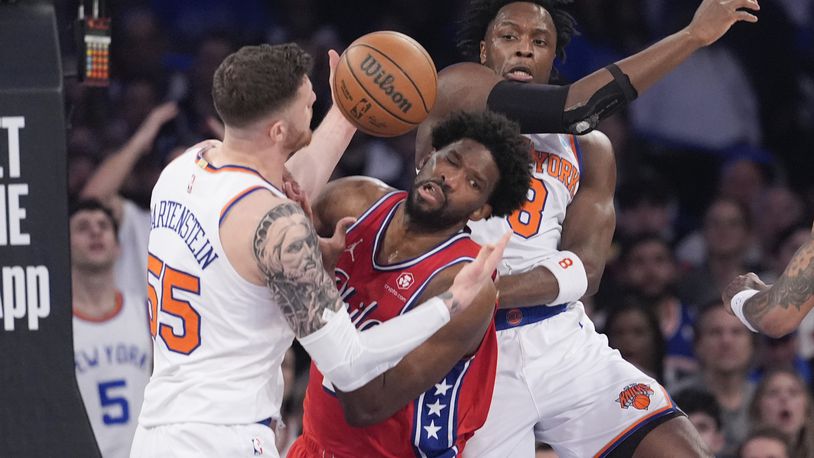 Philadelphia 76ers center Joel Embiid, center, fights for a rebound against New York Knicks center Isaiah Hartenstein (55) and forward OG Anunoby (8) during the first half in Game 1 of an NBA basketball first-round playoff series, Saturday, April 20, 2024, at Madison Square Garden in New York. (AP Photo/Mary Altaffer)