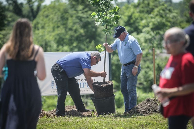Left to right, Harrison Twp.  service manager Merle Cyphers and Harrison Twp.  Trustee Charlie Waldron plants a maple tree in June 2021 at Sinclair Park.  The township hosted a tree-planting kick-off to begin restoring the tree canopy the park lost to Memorial Day tornadoes in 2019. JIM NOELKER/STAFF