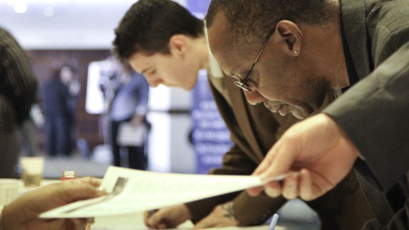 Dayton’s unemployment rate fell slightly from October to November, from 5.6 to 5.3 percent, according to state figures released Tuesday. In this 2013 photo, Leonard Roberts signs in at the “Hiring our Heroes” job fair aimed primarily for veterans and their spouses. CHRIS STEWART / STAFF