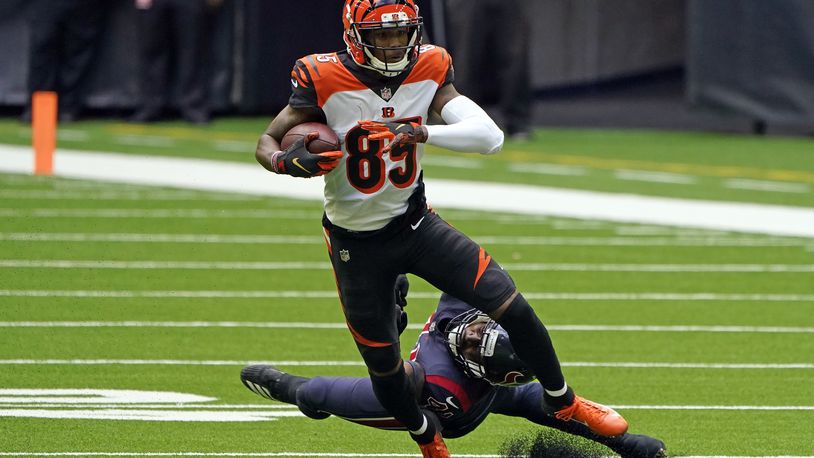 Cincinnati Bengals wide receiver Tee Higgins (85) catches a pass as Houston Texans inside linebacker Zach Cunningham reaches to tackle him during the first half of an NFL football game Sunday, Dec. 27, 2020, in Houston. (AP Photo/Eric Christian Smith)
