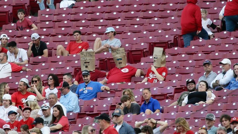 Three fans with bags on their heads watch the Reds play the Cardinals on Friday, April 22, 2022, at Great American Ball Park in Cincinnati. David Jablonski/Staff