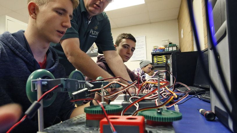 Fairborn High School physics and engineering teacher Darwin Chivers helps students Landon Hiles, left, and Devin Runge with their robotics engineering project as part of Project Lead the Way. More than 70 percent of Fairborn teachers earned the highest rating in the state evaluation system. TY GREENLEES / STAFF