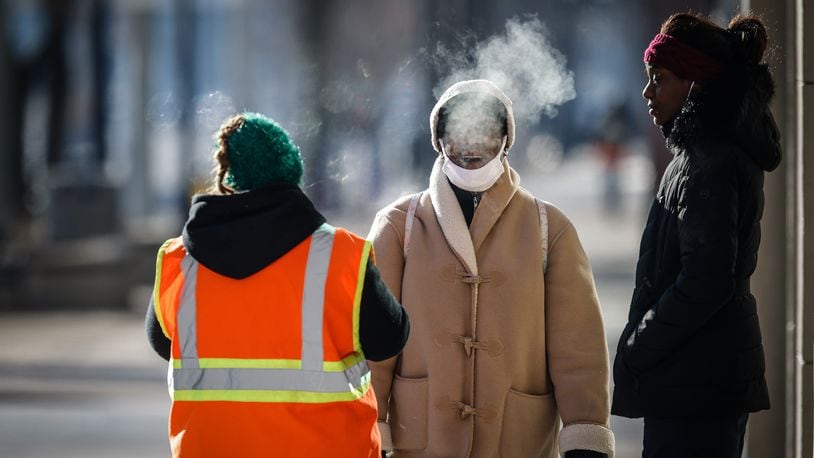 Pedestrians walk in downtown Dayton on a frigid Wednesday morning. Jim Noelker/Staff