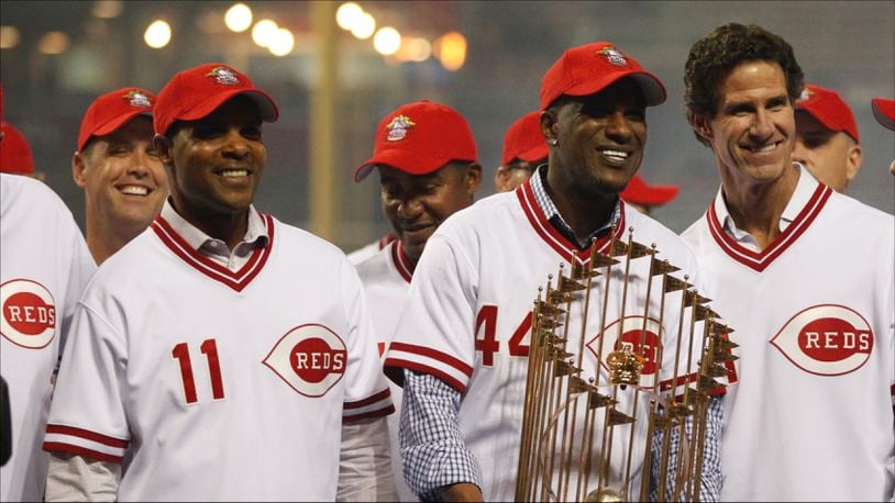 Former Reds Barry Larkin (11), Eric Davis (44) and Paul O'Neill pose with the World Series trophy during a 25th anniversary celebration of the 1990 World Series championship on Friday, April 24, 2015, at Great American Ball Park in Cincinnati. David Jablonski/Staff