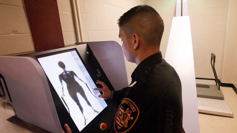 Tyler Viernes, a corrections officer at the Montgomery County Jail, demonstrates a new body scanning system that more than 25,000 inmates a year will pass through. CHRIS STEWART / STAFF