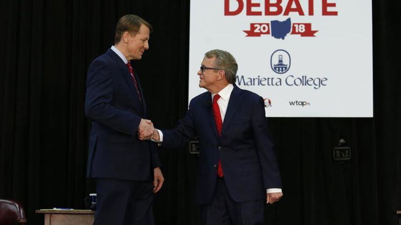 Richard Cordray, left, a Democrat and former head of the Consumer Financial Protection Bureau, and Mike DeWine, Ohio’s Republican attorney general, shake hands at a gubernatorial candidates’ debate in Marietta, Ohio, Oct. 1, 2018. Their race has been a throwback to an era where state politics were more localized and less about Washington.