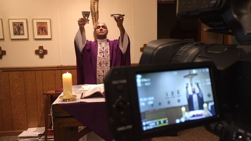 Father Satish Joseph, pastor of Our Lady of the Immaculate Conception and St. Helen in Belmont, livestreams the celebration of Mass at 9 a.m. Monday through Saturday and 10 a.m. Sundays. Typically, there are only two people in the chapel with him when he does this. THOMAS GNAU/STAFF WRITER