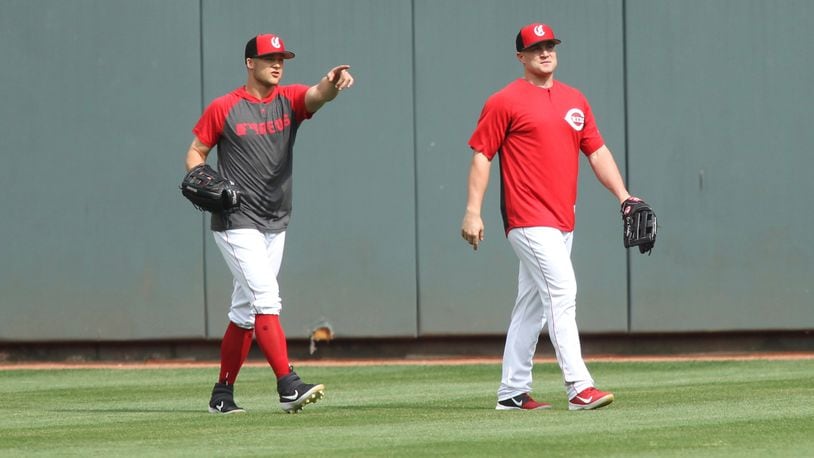 The Reds’ Nick Senzel, left, talks to Scott Schebler in center field during batting practice before a game against the Giants on Friday, May 3, 2019, at Great American Ball Park in Cincinnati. David Jablonski/Staff
