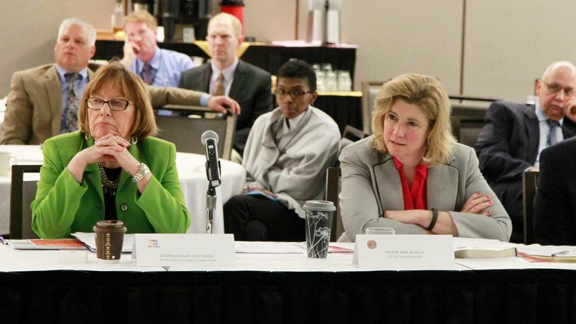 Montgomery County Commission President Judy Dodge and Dayton Mayor Nan Whaley listen to public health officials discuss the heroin epidemic at a joint work session recently. Lebanon is considering joining Dayton and other companies suing drug manufacturers over the opioid epidemic. STAFF