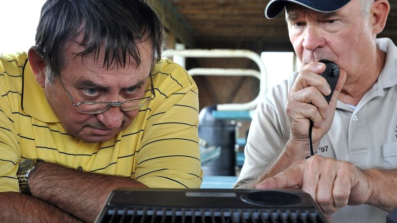 Carl Miller, left, and Bob Beach try to dial in a contact on a ham radio Saturday, June 25 during the Clark County Amateur Radio Association's annual Field Day event at Mid-Ohio Harley Davidson. Staff photo by Bill Lackey