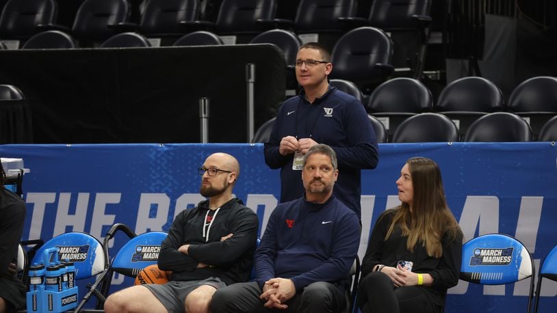 Dayton strength coach Casey Cathrall and trainers Mike Mulcahey and Shelby Davis and Athletic Director Neil Sullivan, back, talk as the team practices for the NCAA tournament at the Delta Center in Salt Lake City, Utah, on Wednesday, March 20, 2024. David Jablonski/Staff