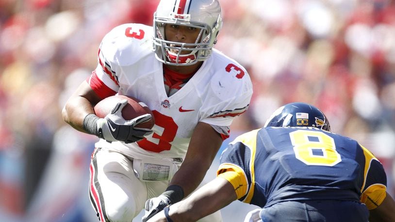 CLEVELAND - SEPTEMBER 19:   Brandon Saine #3 of the Ohio State Buckeyes tries to get around the tackle of Berry Church #8 of the Toledeo Rockets on September 19, 2009 at Cleveland Browns Stadium in Cleveland, Ohio. Ohio State won the game 38-0.  (Photo by Gregory Shamus/Getty Images)