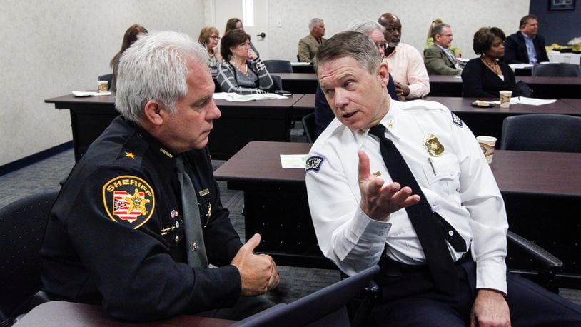 Montgomery County Sheriff Phil Plummer and Dayton police Chief Richard Biehl talk during a steering committee meeting of the Community Overdose Action Team in November 2016. CHRIS STEWART / STAFF