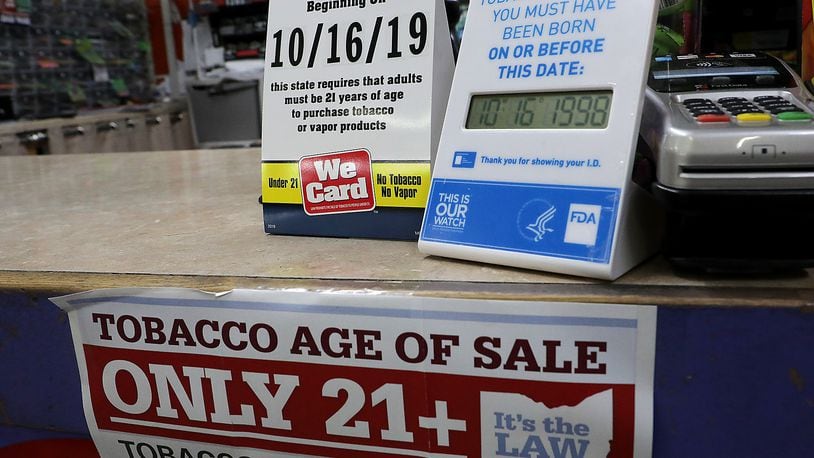 Signs on the counter at the Plum Food Mart in Springfield inform customers that they must by 21-years-old to purchase tobacco and vaping products. BILL LACKEY/STAFF