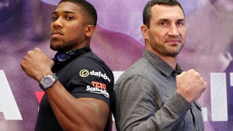 FILE - In this Jan. 31, 2017, file photo, IBF heavyweight champion Anthony Joshua, left, and former heavyweight champion Wladimir Klitschko pose for photos during a news conference at New York's Madison Square Garden. This week, British Olympic gold medalist Joshua meets  Klitschko in a title fight that figures to put a charge into a division that has been neglected for far too long. (AP Photo/Richard Drew, File)