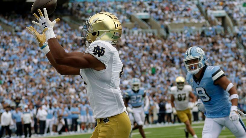 Notre Dame wide receiver Lorenzo Styles (4) hauls in a touchdown pass against North Carolina defensive back Cam'Ron Kelly (9) during the first half of an NCAA college football game in Chapel Hill, N.C., Saturday, Sept. 24, 2022 (AP Photo/Chris Seward)