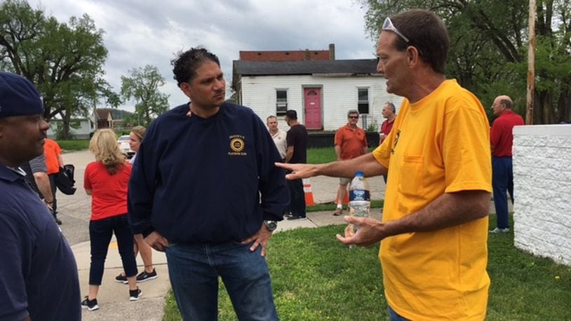 UAW Local 14 member Tony Totti, left, listens as Fuyao worker Larry Yates speaks with him at the UAW rally held in Dayton April 30. THOMAS GNAU/STAFF