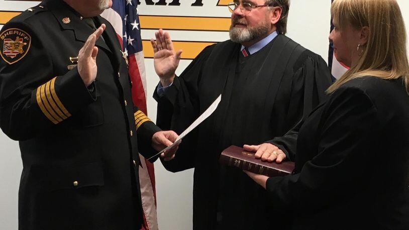 Judge Robin Piper (middle) was sworn in this month to his second term as a judge in the 12th District Court of Appeals. Administering the Oath of Office to Piper was Butler County Sheriff Richard Jones. Melissa Spurlock, former legal assistant to Piper and a current employee of the Butler County Sheriff’s Office, is shown holding the Bible during the swearing in. CONTRIBUTED