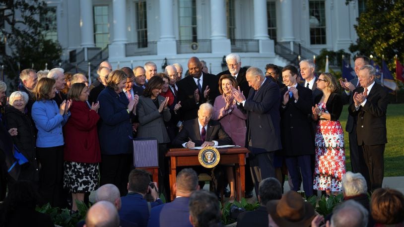 As Dayton Mayor Nan Whaley and members of Congress and other officials look on, President Joe Biden signs the $1 trillion infrastructure bill into law at the White House on Monday, Nov. 15, 2021. (Doug Mills/The New York Times)