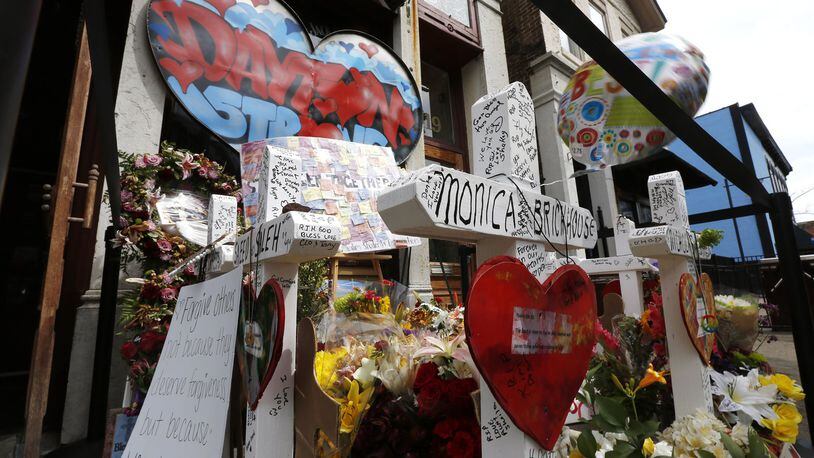 Memorials to victims of the mass shooting on August 4 have begun to shrink in the Oregon District and some business owners would like to have them removed. Many people continued to visit the memorials during the Friday lunch hour. TY GREENLEES / STAFF
