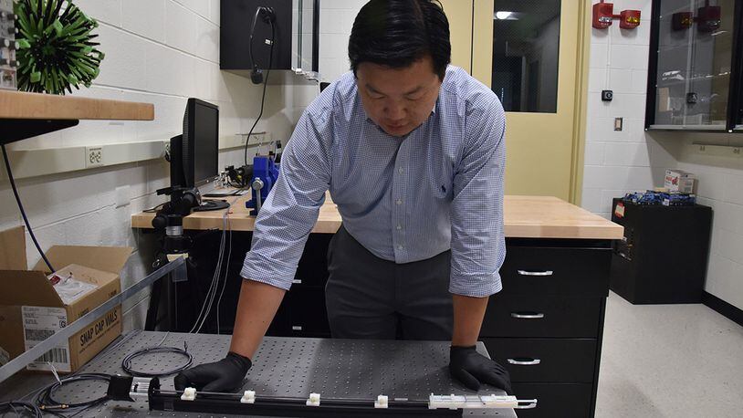 Dr. Vincent Chen, an Air Force Research Laboratory scientist, demonstrates the experimental setup used to trigger shape change in soft, magnetically responsive elastomers. (U.S. Air Force photo/Spencer Deer)
