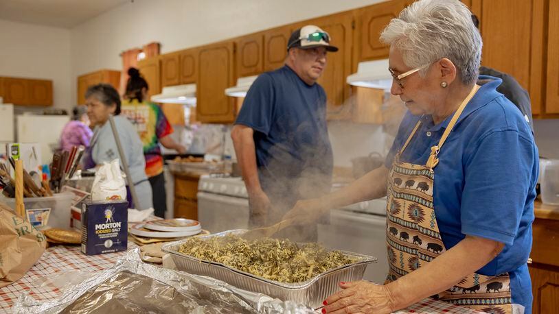 Ethel Humble, an elder at the Springfield United Methodist Church in Okemah, Okla., stirs a steaming tray of wild onions at the church's annual wild onion dinner, April 6, 2024. The church is on the Muscogee Nation's reservation, where the meals using wild onions picked by the community are an annual tradition. (AP Photo/Brittany Bendabout)