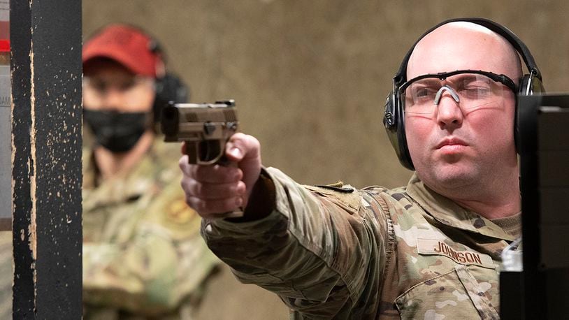 Tech. Sgt. Dakota Johnson, 88th Security Forces Squadron, takes aim with his M18 at the unit’s indoor shooting range May 11 on Wright-Patterson Air Force Base, as a combat arms instructor looks on. The squadron hosted a shooting competition as part of its annual Police Week activities. U.S. AIR FORCE PHOTO/R.J. ORIEZ