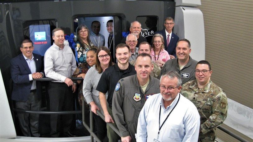 Members of the Simulators Division and 552nd Air Control Group pose in front of the first delivery of the DRAGON Flight Training Device at Tinker Air Force Base, Okla., in December 2019. The new simulator replaces 1970s analog technology with digital, automated aircraft navigation functions, and it ensures E-3 Sentry (AWACS) aircraft are compliant with current and future air traffic control requirements.(Courtesy photo)