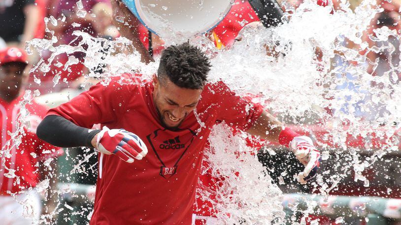The Reds’ Billy Hamilton gets doused with a bucket of water by Ivan De Jesus Jr. after scoring the winning run on a passed ball against the Brewers on Sunday, July 17, 2016, at Great American Ball Park in Cincinnati. David Jablonski/Staff