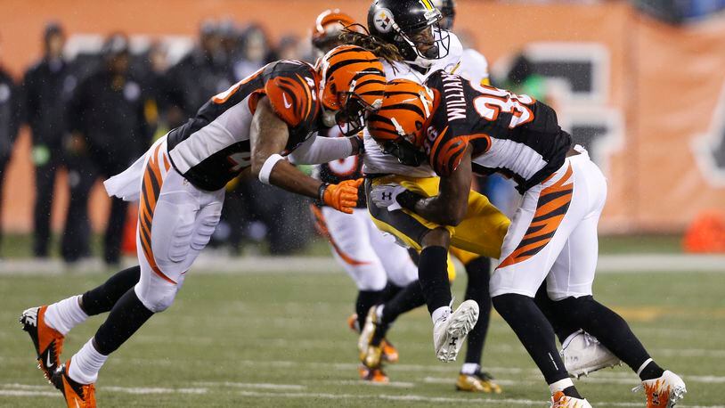 Pittsburgh Steelers’ Markus Wheaton (11) is tackled by Cincinnati Bengals’ Shawn Williams (36) and George Iloka (43) during the first half of an NFL wild-card playoff football game Saturday, Jan. 9, 2016, in Cincinnati. (AP Photo/Frank Victores)