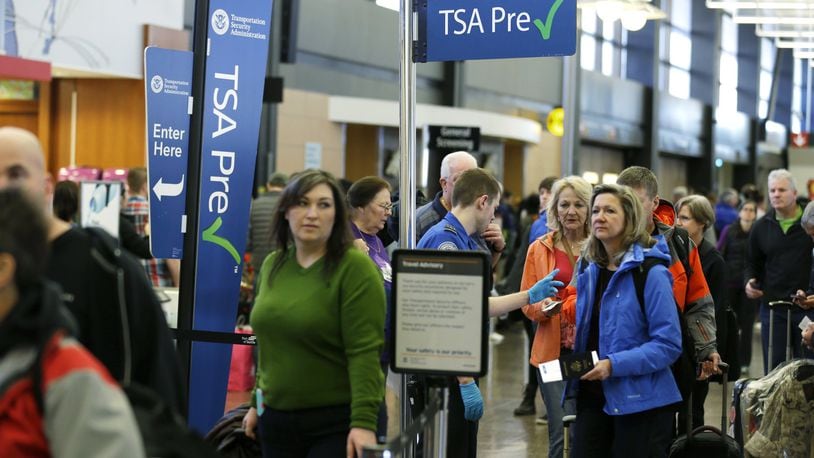 FILE - In this March 17, 2016, file photo, travelers authorized to use the Transportation Security Administration’s PreCheck expedited security line at Seattle-Tacoma International Airport in Seattle have their documents checked by TSA workers. Service members are already enrolled in TSA Precheck, but many do not know they are. (AP Photo/Ted S. Warren)