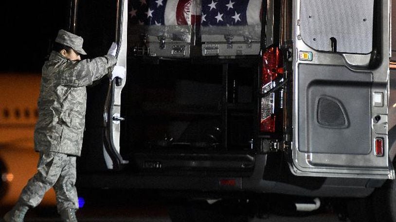 Tech. Sgt. Karina Urgilez-Santamaria closes a vehicle holding transfer cases containing the remains of Master Sgt. Christopher J. Raguso, left case, and Capt. Christopher T. Zanetis at Dover Air Force Base, Del., on Sunday, March 18, 2018. According to the Department of Defense, Raguso, 39, of Commack, N.Y., and Zanetis, 37, of Long Island City in the Queens borough of New York, both died March 15, 2018, when a U.S. helicopter crashed in western Iraq. The cause of the crash is under investigation. (AP Photo/Steve Ruark)