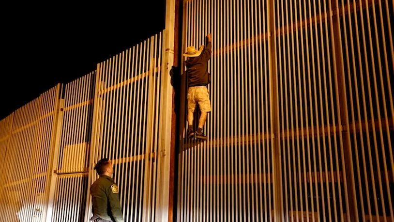 A U.S. Border Patrol agent, apprehends a male trying to climb the secondary fence into Border Field State Park, San Diego, from Playas de Tijuana, along the U.S.- Mexico border in San Diego, Calif., on July 31, 2017. (Gary Coronado/Los Angeles Times/TNS)